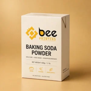 Hero shot of a retail baking soda carton with the Bee Printers logo printed on the front panel, warm golden-beige studio backdrop