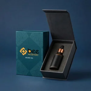 Closed teal patterned gift box beside an open black hinged box with grey foam holding a dark beard oil bottle with a copper collar on a dark blue background with the Bee Printers logo, showing custom beard oil gift boxes