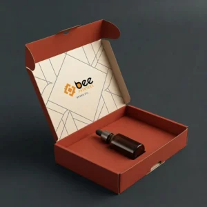 Open terracotta mailer box with a cream geometric-patterned inner lid showing the Bee Printers logo and a single dark amber dropper bottle lying inside on a dark grey background, showing custom beard oil mailer boxes
