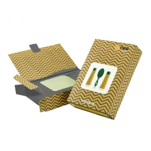 Two mustard-yellow and grey chevron-pattern bookend boxes on a white background, one open and empty with a pale panel visible inside and one closed with an illustration of tubes and a brush on the front and a small Bee Printers logo at the top right, showing custom bookend boxes