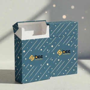 Two teal cigarette packs with white diagonal lines and dots on a light grey background, one open and empty with a white interior in front and one closed behind it, with the Bee Printers logo in the centre of each front, showing custom cardboard cigarette boxes.
