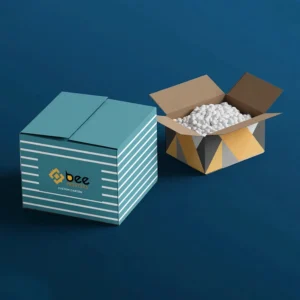 A closed teal carton with white horizontal stripes and the Bee Printers logo on its front beside an open yellow and grey geometric carton filled with white packing peanuts on a dark blue background, showing custom carton boxes