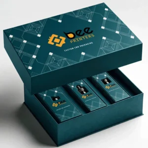 Open dark teal rigid box with white geometric line pattern and Bee Printers logo, revealing three matching inner boxes with dropper bottles on a light grey background, showing custom cbd packaging