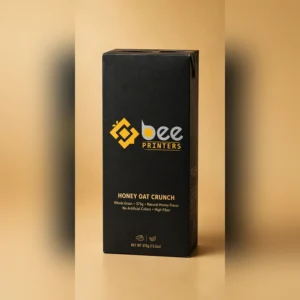 Custom cereal boxes as a tall upright retail carton with the Bee Printers logo printed on the front panel, closed hero box on a warm golden-beige studio backdrop