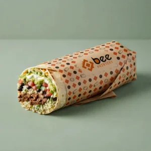Light tan burrito wrapping paper with an orange diamond and brown dot pattern and the Bee Printers logo wrapped around a burrito with beef, rice, beans, tomato and guacamole filling visible at the open end on a sage green background, showing custom custom burrito wrapping paper