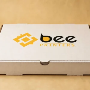 Custom Detroit pizza box in warm white, long and rectangular, with the Bee Printers logo printed on the closed lid, single hero box on a warm golden-beige studio backdrop