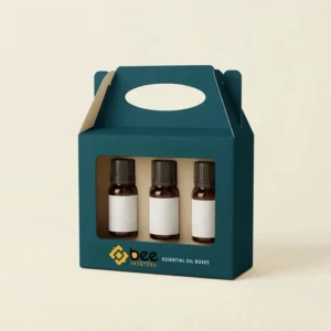 A dark teal custom essential oil gable boxes design with a large front window showing three amber bottles with black caps and plain white labels, plus the Bee Printers logo on a cream background.