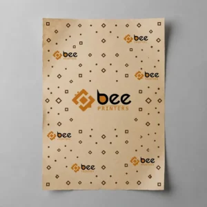 A flat light kraft paper sheet printed with small brown diamond and dot patterns and repeating Bee Printers logos with one large logo in the centre on a grey background, showing custom kraft paper.