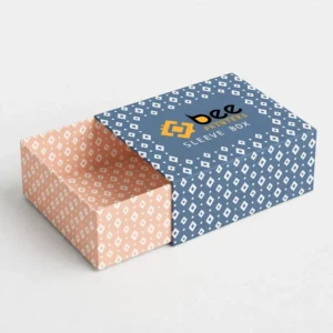 A blue sleeve box with a white diamond pattern partially slid over a peach patterned empty tray on a white background, showing custom luxury sleeve boxes
