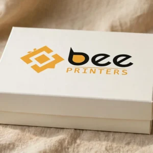 Custom rigid gift boxes — closed ivory-white rectangular rigid gift box with the Bee Printers logo printed on the lift-off lid