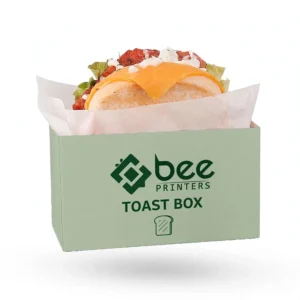 Open sage green box lined with white parchment holding a cheese and salad toast sandwich on a plain white background, custom toast packaging boxes with the Bee Printers logo on the front.